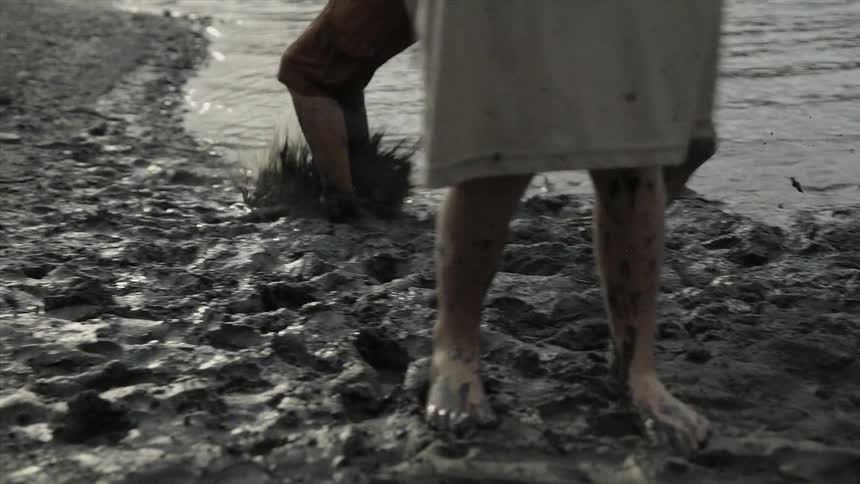 Children jump into mud causing it to splash up
