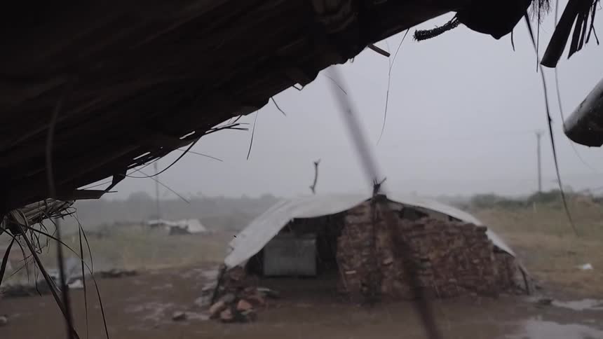 Rain drips from the roof of a hut