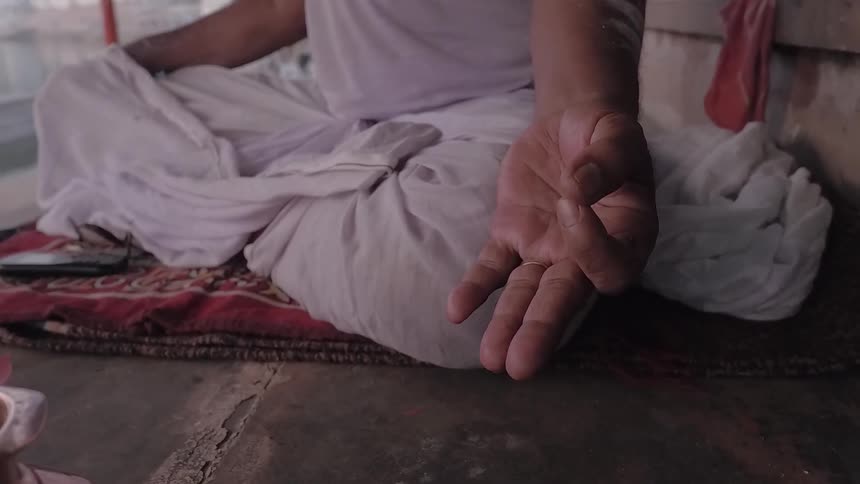 A man is sitting on a cloth and meditating during the day
