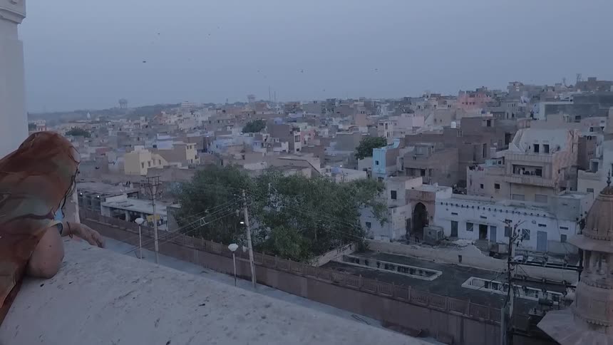 A woman is overlooking the city from her balcony