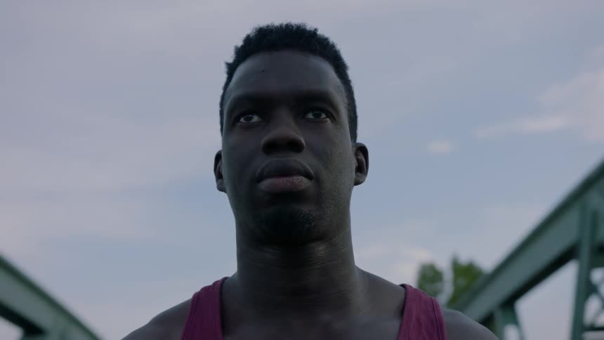 A man is standing outside under the cloudy sky