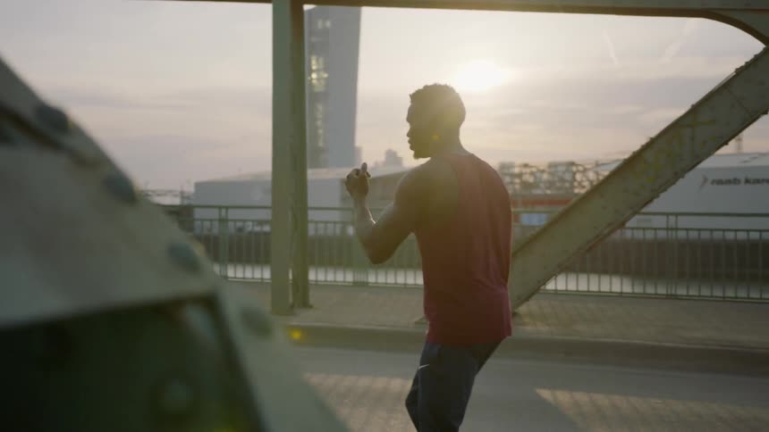 A man is standing on a bridge shadowboxing
