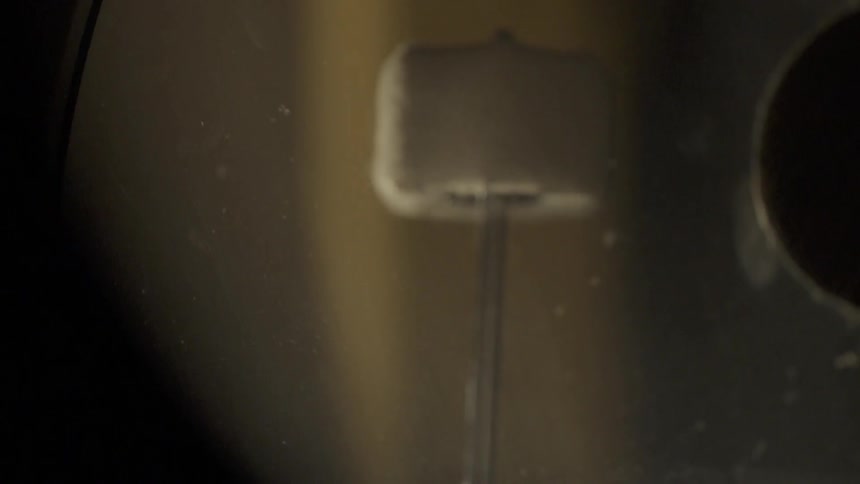 Beater head is hitting the drumhead of a bass drum
