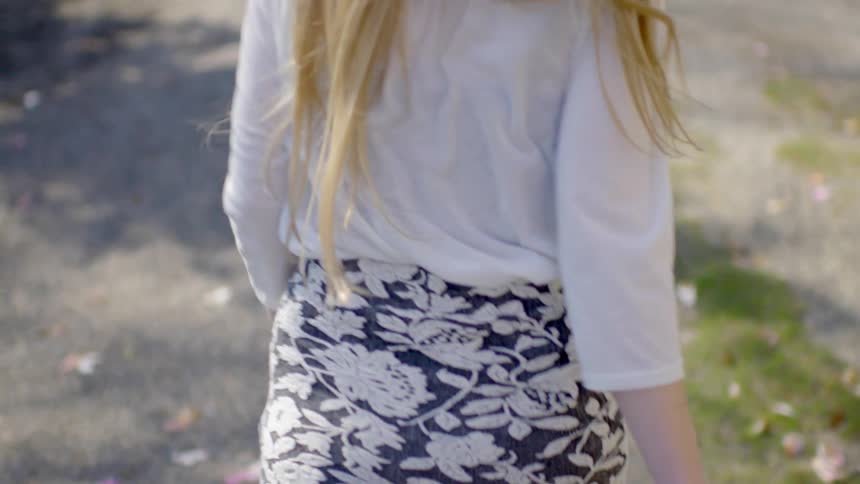 A girl is walking down a dirt road