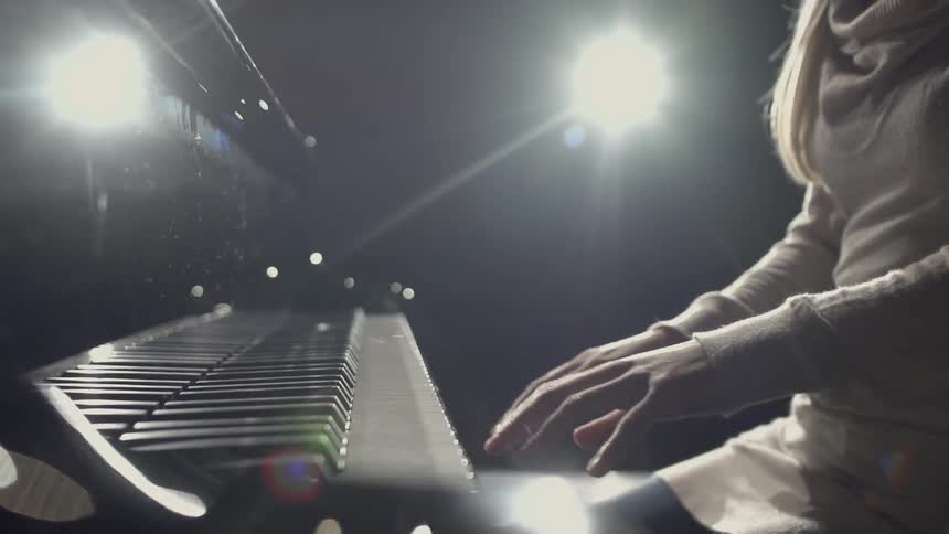 A woman sits at a piano
