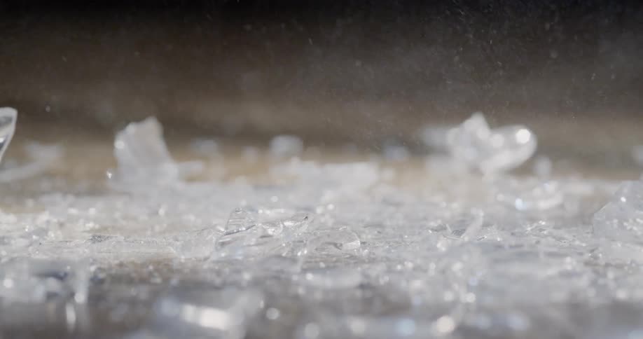 Pieces of glass fall to the floor and shatter