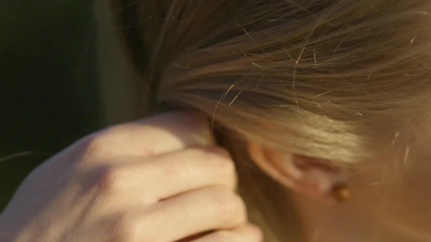 A woman is brushing her hair close up