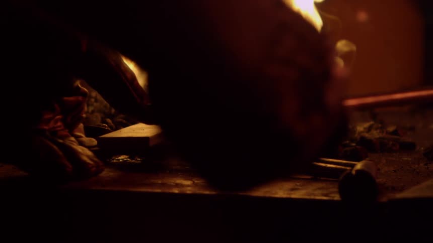 Person heating metal in a fire