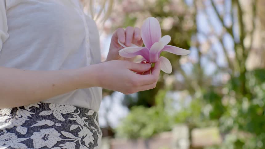 A woman is touching the petals of a large flower