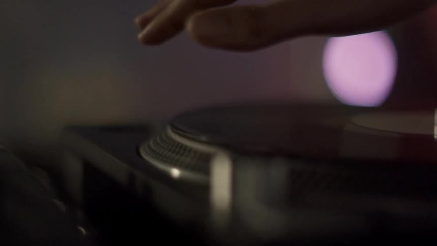 Person spins a record on a turntable
