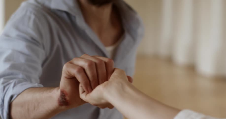 Woman reaches her hand out to a man who accepts it
