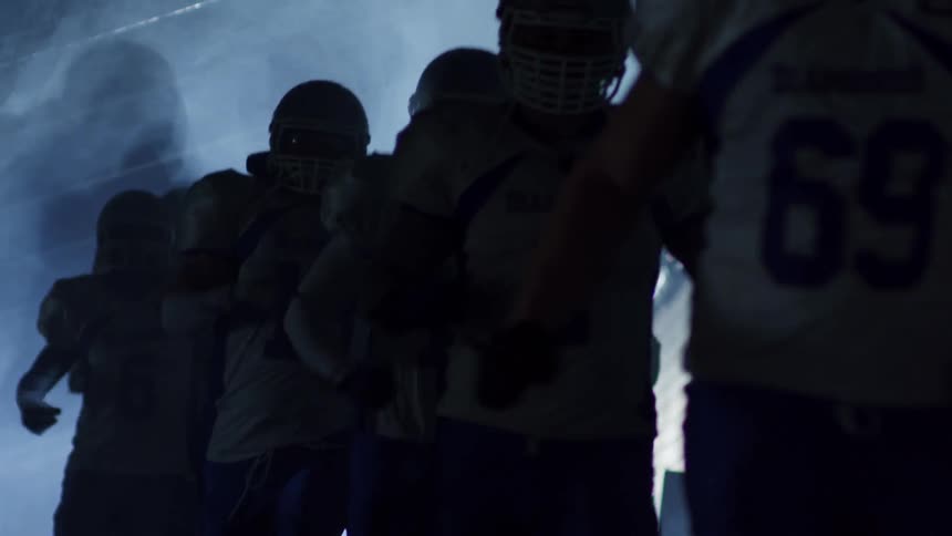 A football teams runs down a hallways