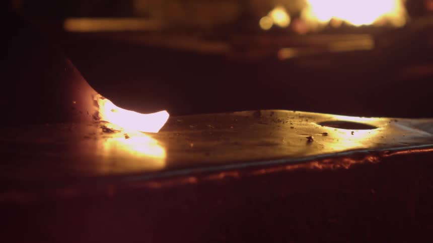 Hammer hitting a glowing piece of metal