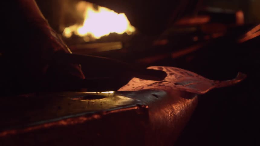 A blacksmith hammers metal