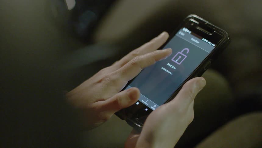 A woman is pressing the screen on her phone to lock it