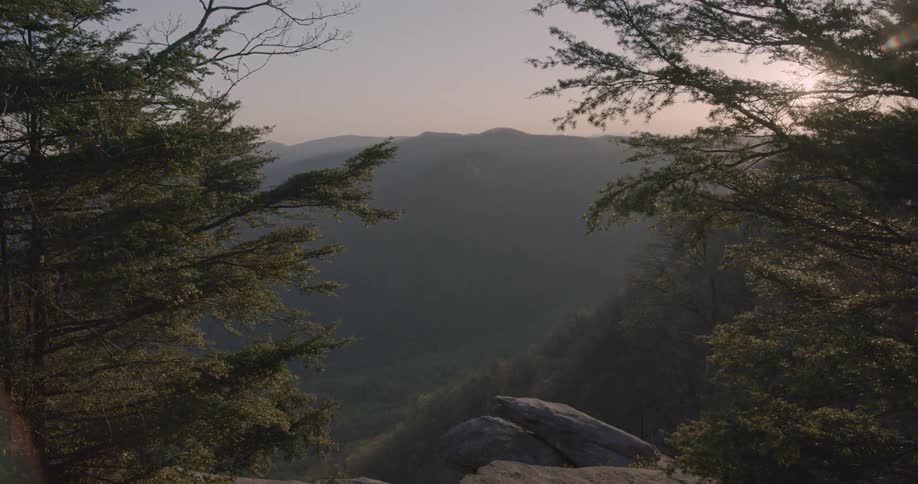 The sun shines in the valley between mountains
