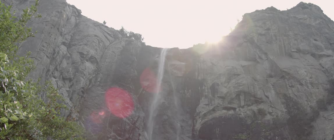 A waterfall flows over a rocky cliff