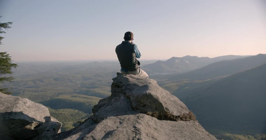 A person photographing on the top of the mountain