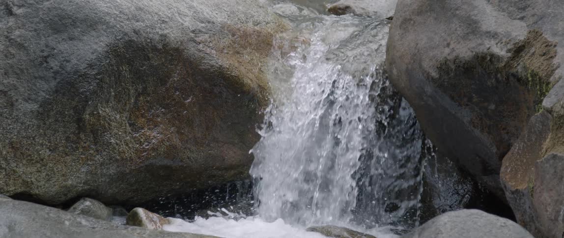 Water gushes over large rocks