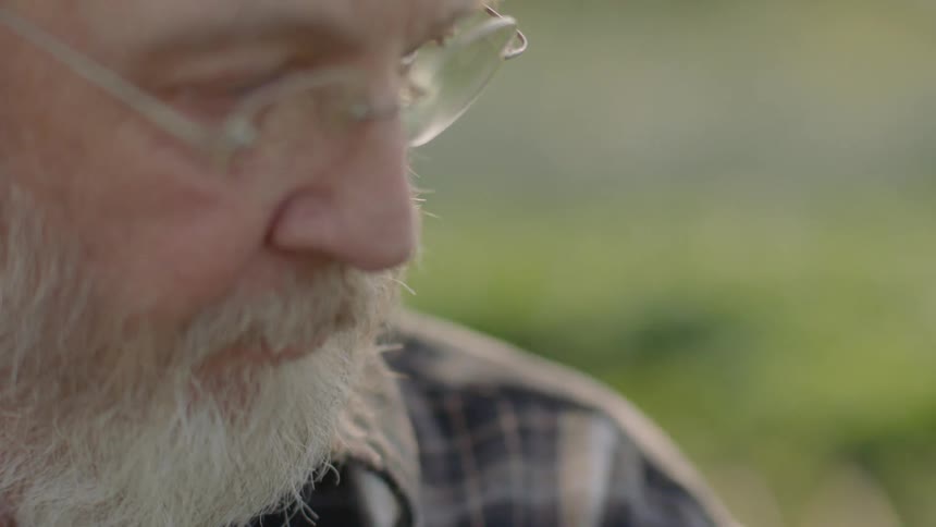 A man wearing glasses leans to his side