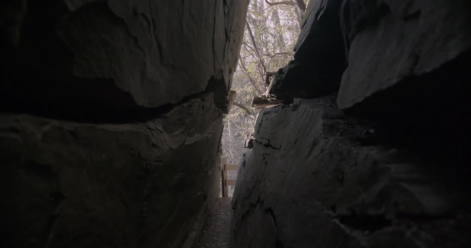 A fence post is seen at the end of a rock crevice