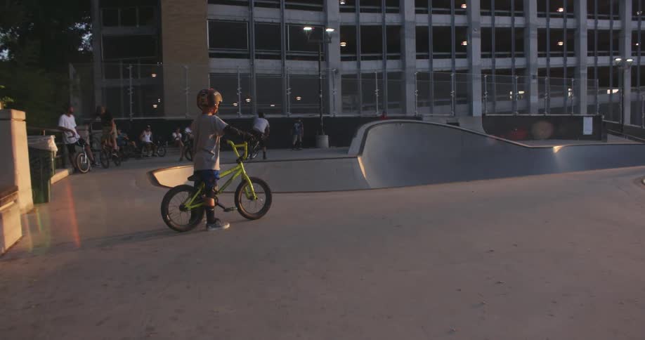 Boys performing bike tricks in an urban skatepark