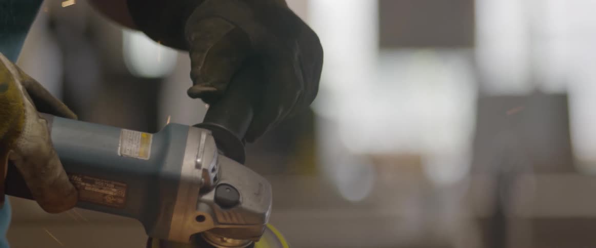 Man uses a power tool with sparks flying around