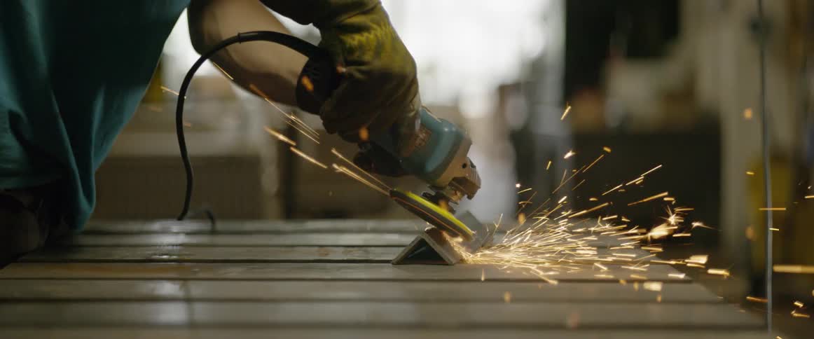 A man is using a grinder on some metal