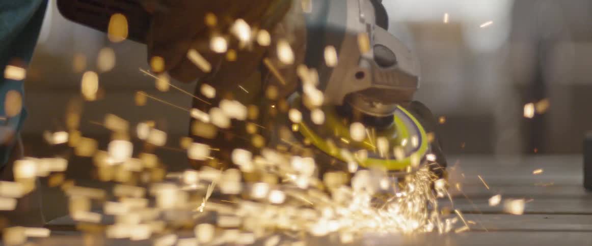 A person is working cutting metal with a tool