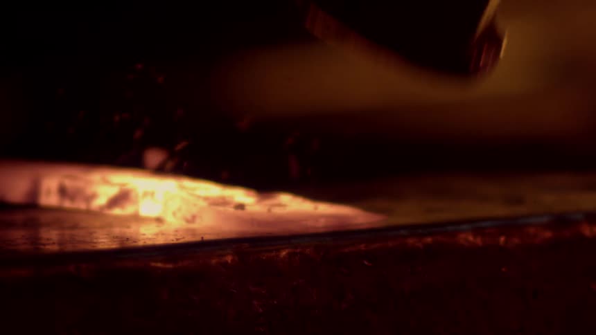 Person hammering hot metal to form it