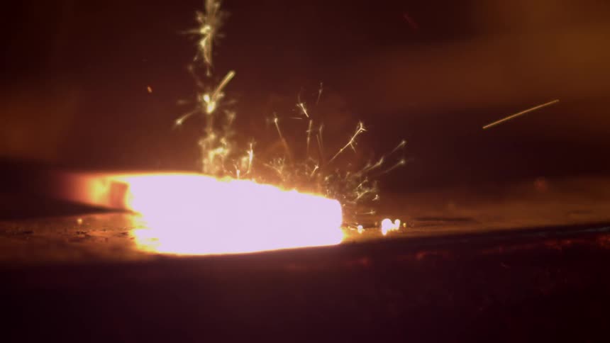 Person forging some red hot metal with a hammer