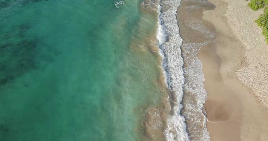 The waves move fast crashing on the sand of the beach
