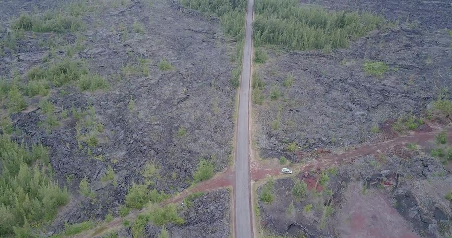 A highway runs through a rocky, grassy plain