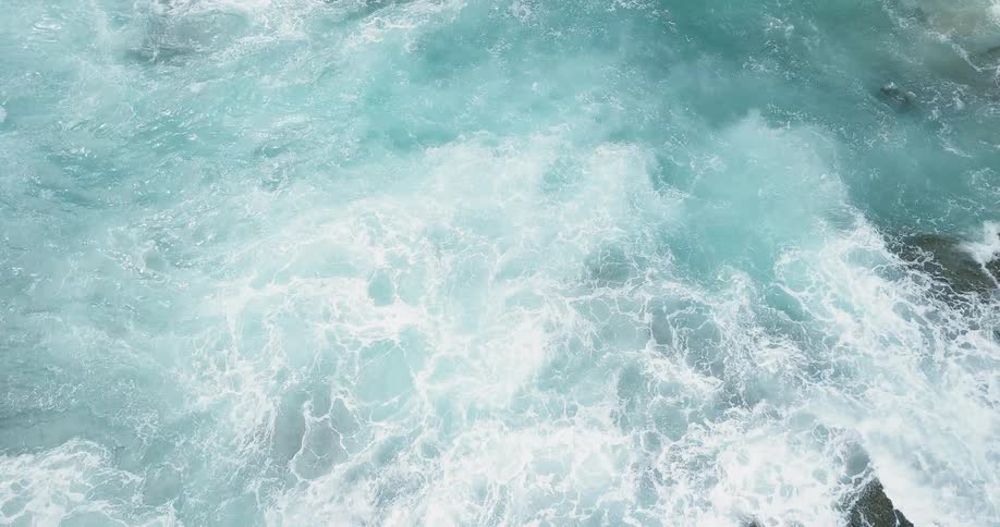 Waves rush and crass in a lagoon during the day