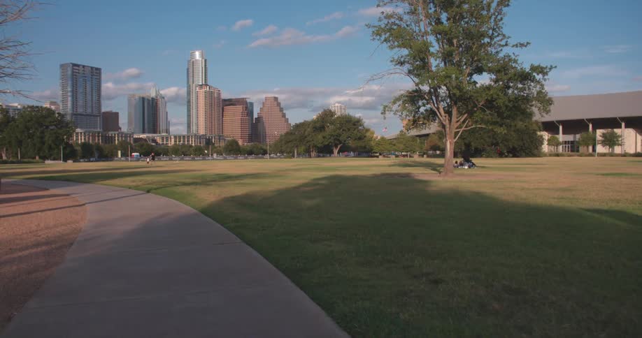 A large grass lawn sprawled in front of skyscrapers