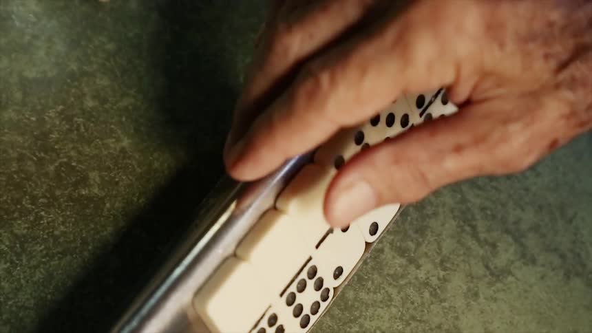 A person picks up a domino