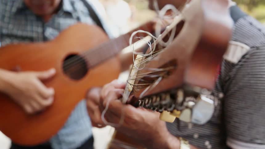 Men face one another and play guitars