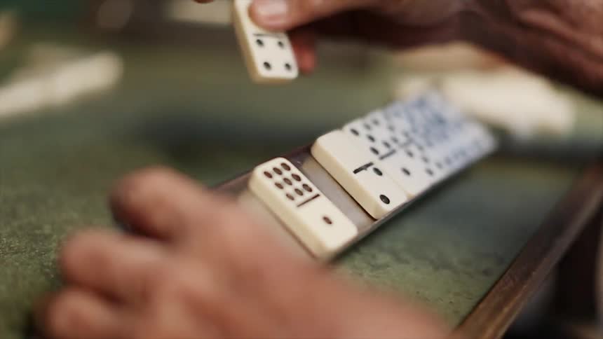Man playing dominoes with others