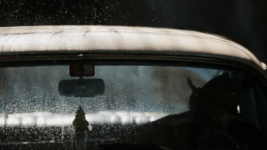Raindrops bounce off a truck roof as a cowboy climbs inside