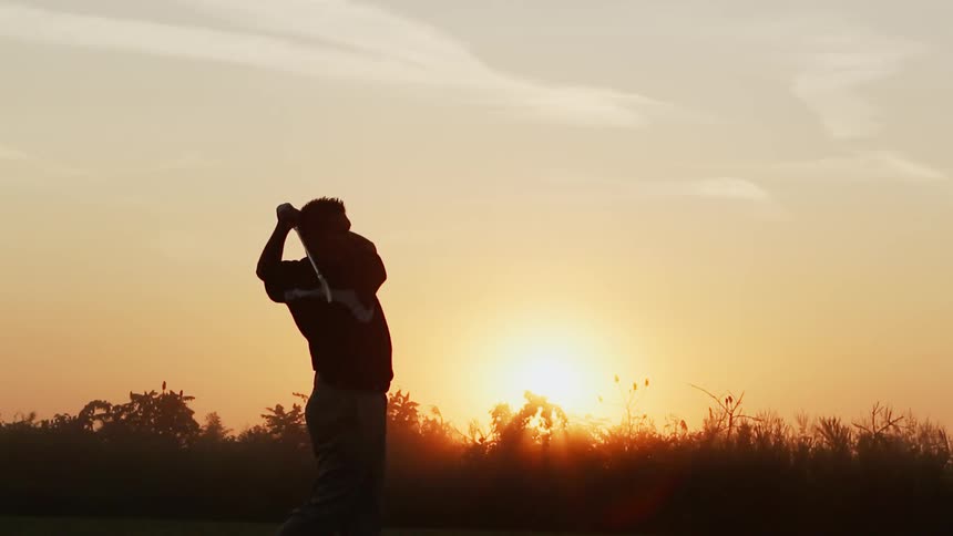 Someone is hitting a golf bowl at dawn