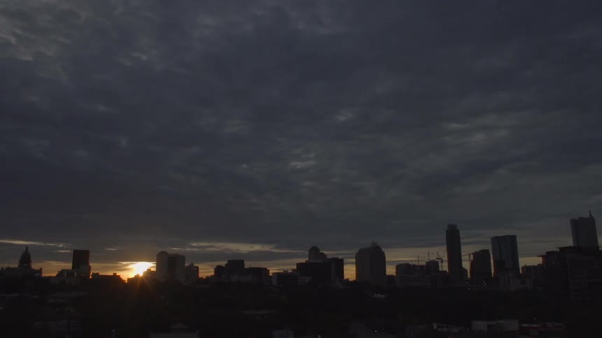 View of a city skyline with heavy clouds at sunset