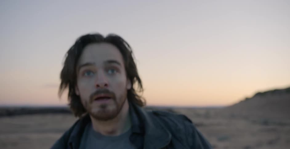 A man runs up and jumps at sunset