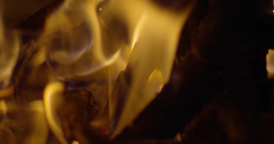 Flames are consuming the wood in a bonfire at night