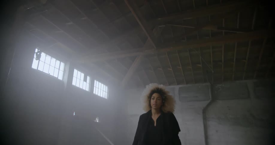 Woman walks across empty warehouse floor