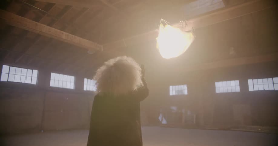 Woman walks across empty warehouse floor