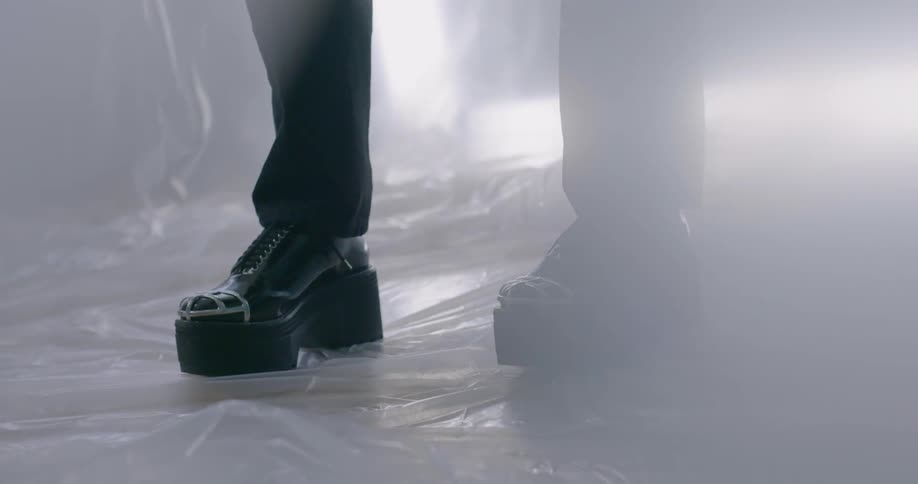 Person in black shoes stands on plastic covered floor