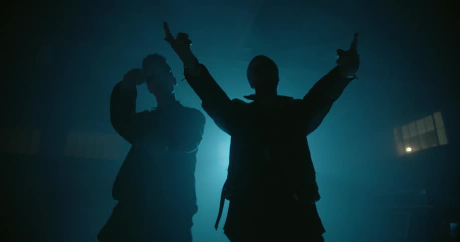 Men dance in front of a spotlight