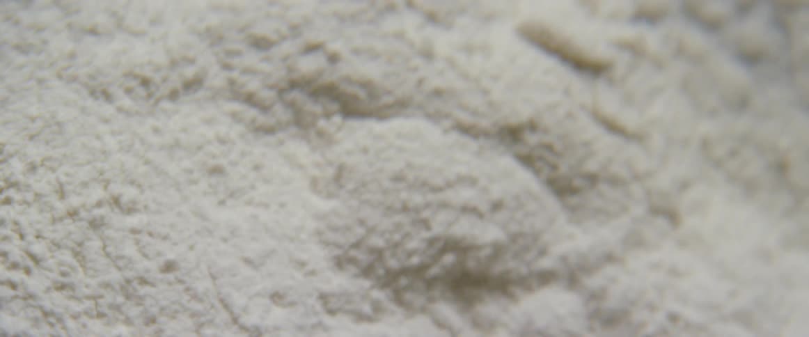 A pile of white sand is being vibrated