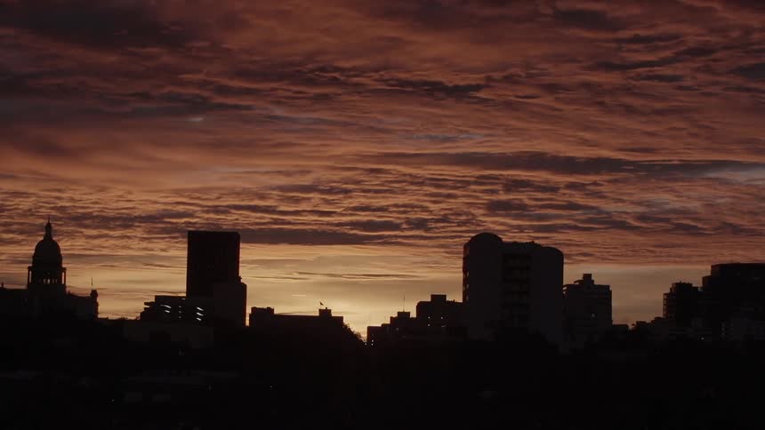 Clouds moving over a city skyline at dusk
