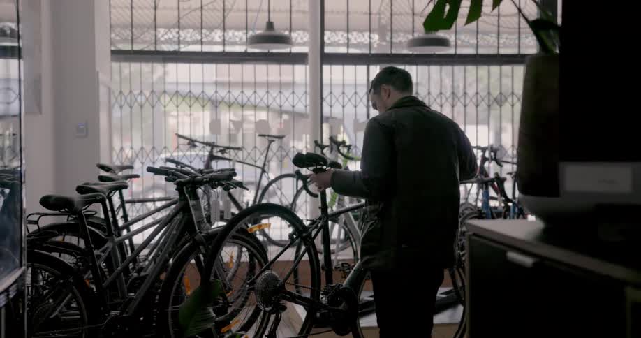 A man is getting a bike from a row of bikes